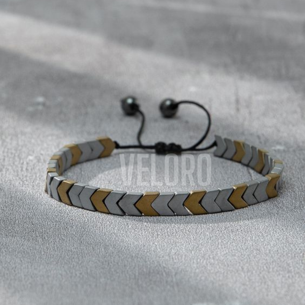 Bracelet with gray and gold chevron pattern on a gray background veloro