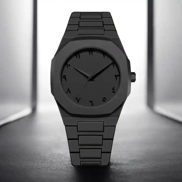 Black wristwatch on a reflective surface with a neutral background