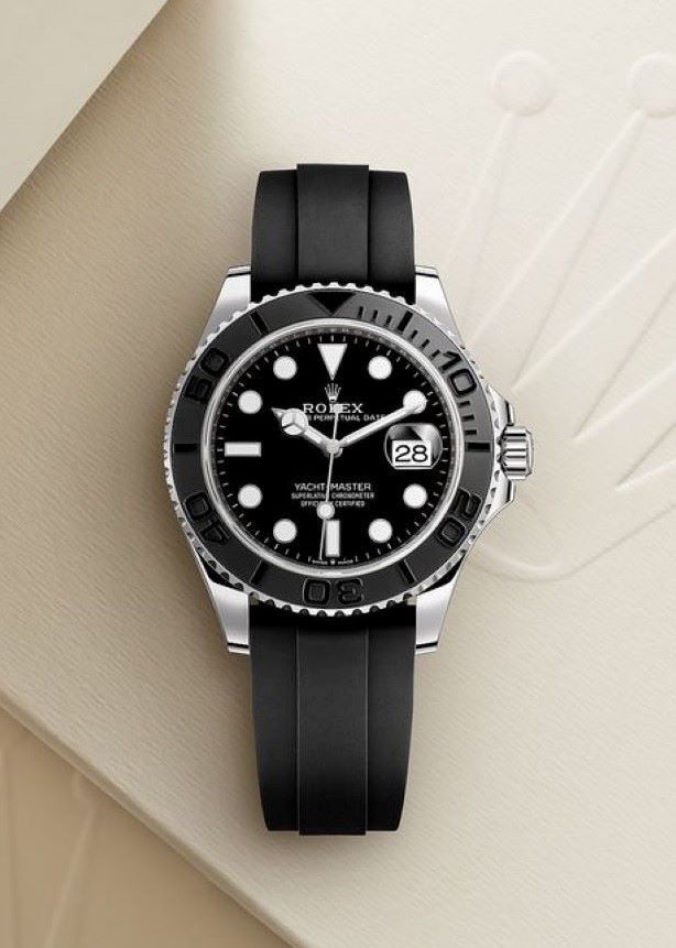 Submariner black dial automatic men’s watch with stainless steel case and black rubber strap on beige background.